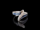 bague en argent ornée de pierres bleues et blanches sur un fond noir