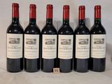 six bottles of wine are lined up on a table