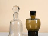 two glass bottles sitting next to each other on a table