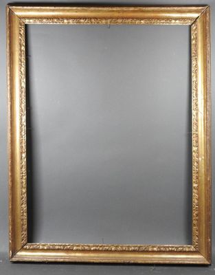 un miroir à cadre doré accroché à un mur gris sur fond noir