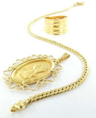 un gros plan d'un collier en or avec une pièce suspendue à une chaîne