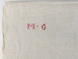 a close up of a piece of cloth with a red cross stitch on it
