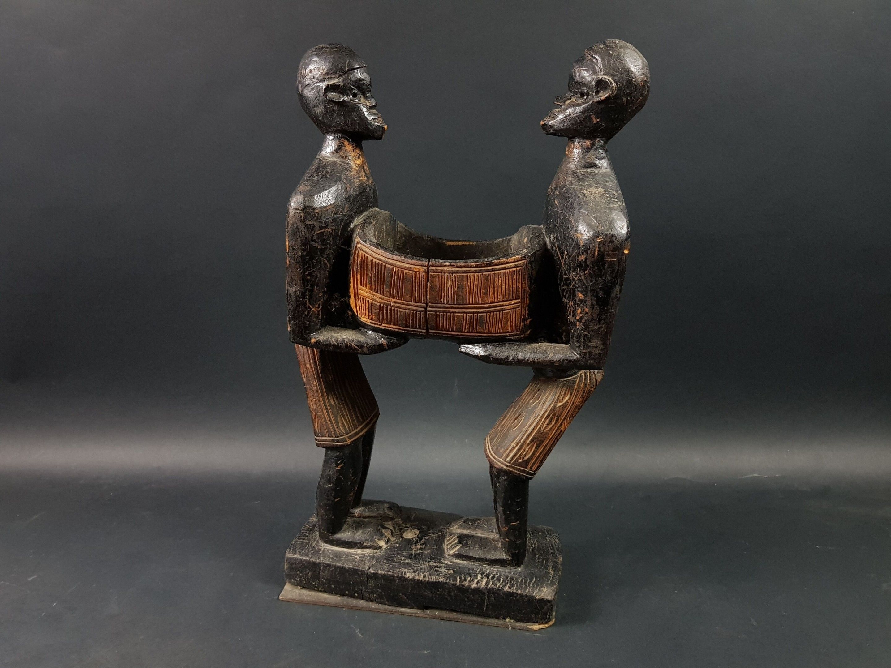 Statue, Sénoufo (?), nord de la Côte d'Ivoire Imposante statue figurant deux hommes se faisant face portant un coffre...