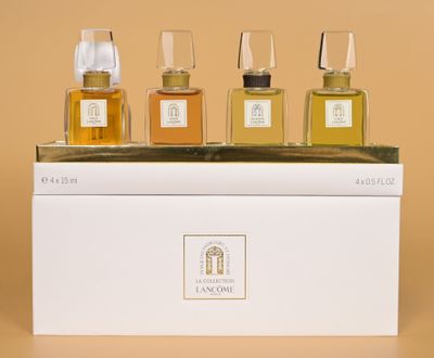 three bottles of perfume sitting on top of a white box