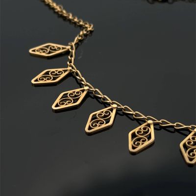 gros plan d'un collier en or sur une surface noire