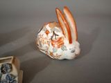 a small ceramic rabbit that is sitting next to a box