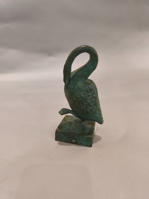 statue représentant un oiseau posé sur un rocher, sur fond blanc