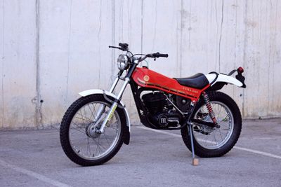 a red and black motorcycle parked in a parking lot