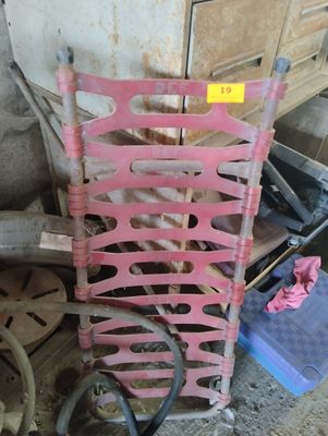 a pink chair that is sitting next to a pile of tools
