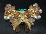 an image of a close up of a brooch on a black surface
