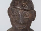 a wooden statue of a man with a bird on his head