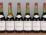 six bottles of wine are lined up in a row on a table