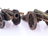 two old cannon wheels sitting next to each other on a white surface