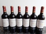 six bottles of wine are lined up on a table