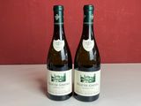 deux bouteilles de vin posées sur une table l'une à côté de l'autre