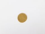 a close up of a gold coin on a white surface