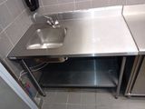 a stainless steel sink in the corner of a kitchen