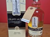 une photo montrant une bouteille de whisky posée à côté d'une boîte sur une table