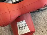 a red blow dryer sitting on the floor next to a black cord