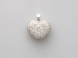 un pendentif en forme de cœur en or blanc et diamants sur fond blanc