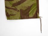 a green and brown camouflage cloth with a bird on it