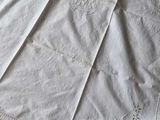 a white table cloth on a table next to a pair of scissors and a pair of scissors