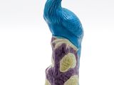 une figurine représentant un paon perché sur un rocher