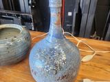 two vases sitting on a wooden table next to each other