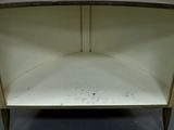 a corner of a cabinet with a shelf on top of it