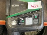 a tire with a green sticker on it next to a pile of tires