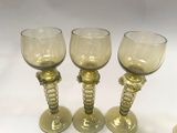 three wine glasses sitting next to each other on a table
