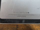 the back of a laptop computer sitting on top of a wooden table