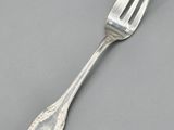 an antique silverware fork on a gray surface
