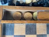 chess pieces in a wooden box on a checkered floor