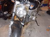 a black motorcycle parked in a garage next to a black car