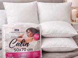 trois oreillers posés sur un lit, sur lequel se trouve un autre oreiller