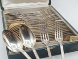 three silver spoons and two silver spoons in a case