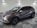Une voiture marron et blanche est garée sur un sol à damier.