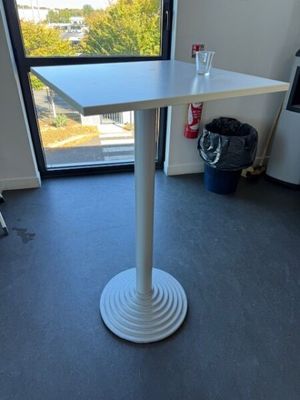 une table blanche dans une pièce avec vue sur la ville