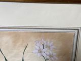 painting of a white flower in a gold frame on a blue wall