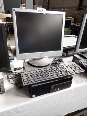 a lot of computers on a table with a keyboard and monitor