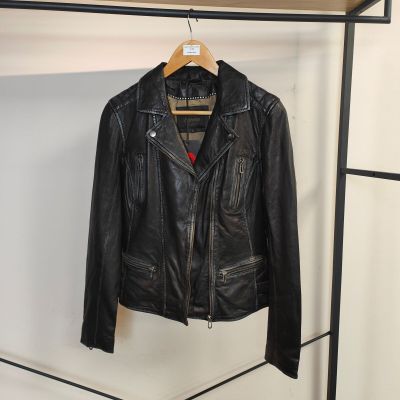 une veste en cuir noir suspendue à un portant dans une pièce