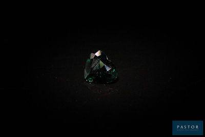 gros plan d'un diamant vert sur une surface noire