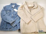 two jackets and a jacket sitting on top of a white table