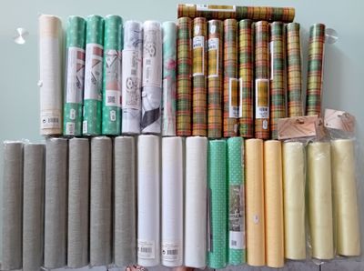 de nombreux rouleaux de tissu posés sur un support dans une pièce