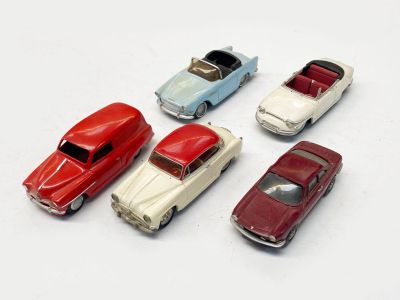 plusieurs petites voitures sont alignées sur une surface blanche