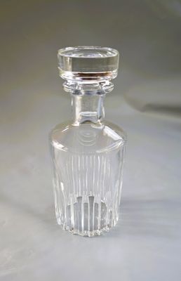 une bouteille en verre transparent munie d'un bouchon, posée sur une table