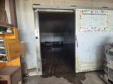 une chambre sale dans laquelle se trouvent un réfrigérateur et une poubelle
