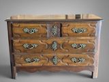 une commode en bois avec des ferrures en laiton sur les tiroirs