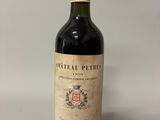 une bouteille de vin rouge posée sur une table blanche